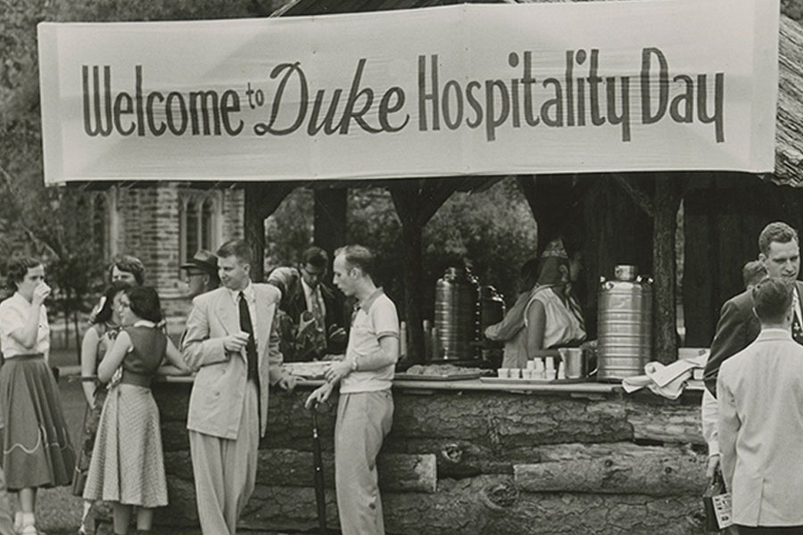 Historical photo of students standing below a "Welcome to Duke Hospitality Day" banner