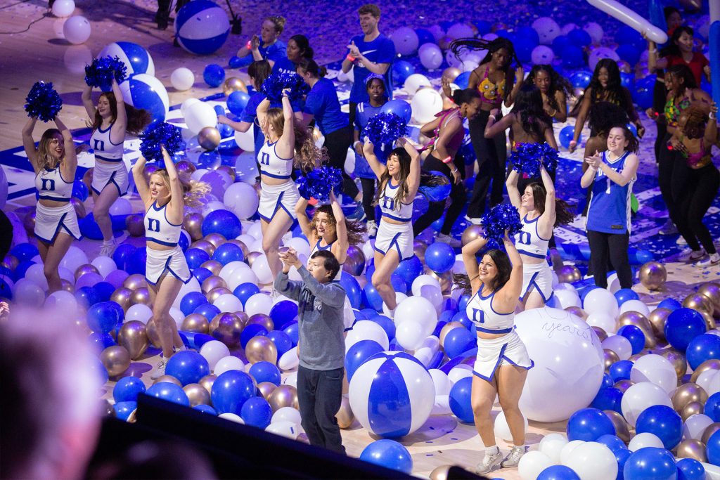 Ken Jeong does a cheer routine with the Duke cheerleaders among blue and white baloons
