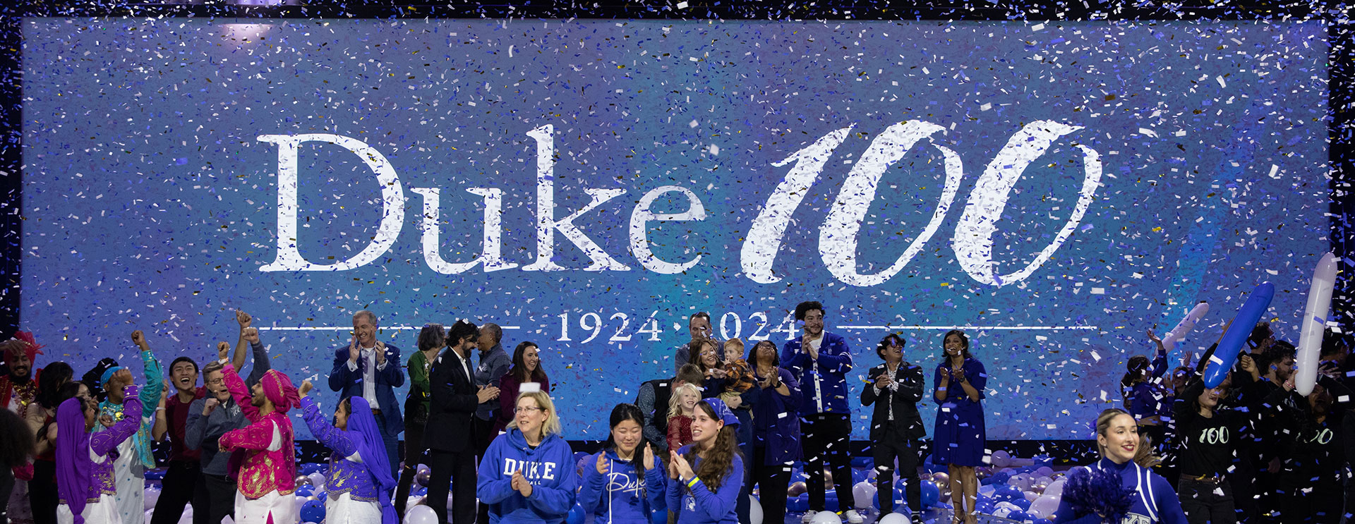 Confetti falls in front of the Duke100 logo on the big screen