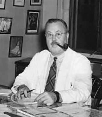 Wilburt C. Davison sitting at a desk in his office