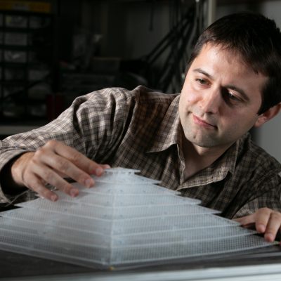 Bogdan Popa touching the pyramid-like 3-d acoustic cloaking device