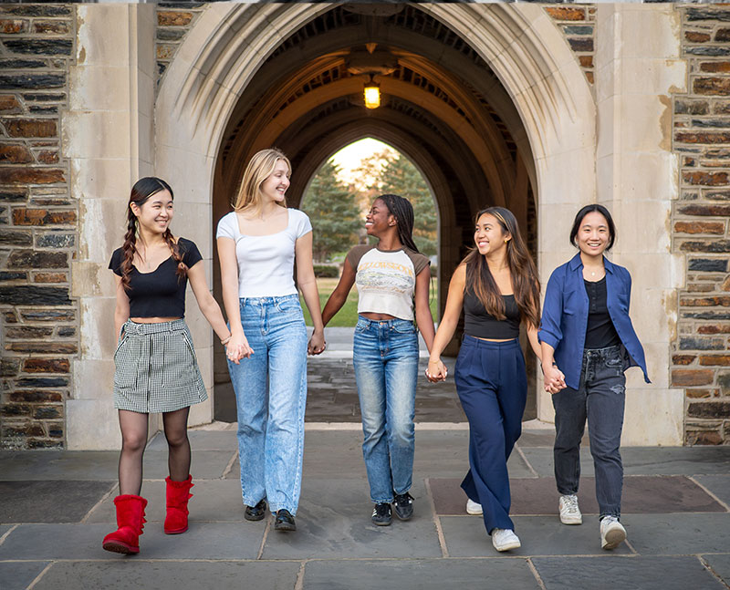 Five women posing in front of a Duke arch in 2023