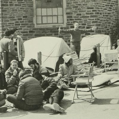 Students sit in a circle next to tents outside Cameron Indoor Stadium