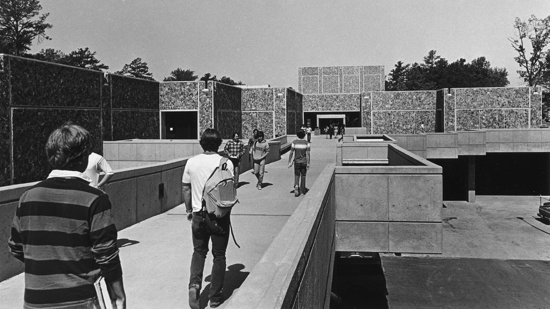 Students walking the narrow concrete walkway to the Bryan Center