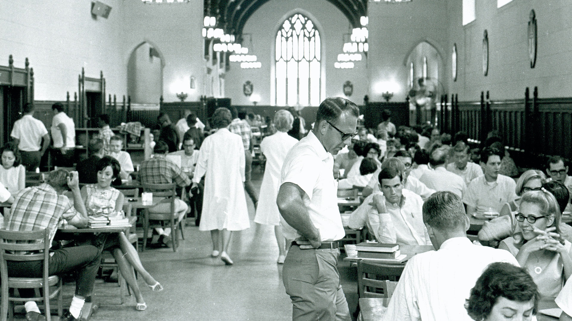 An old photo of people eating in the Great Hall