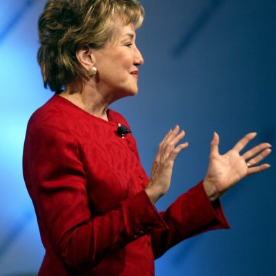 Elizabeth Dole gesturing with her hands in front of her while speaking at a conference