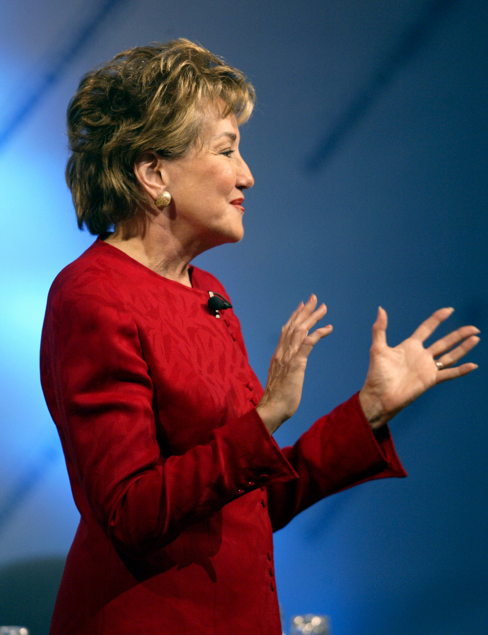 Elizabeth Dole gesturing with her hands in front of her while speaking at a conference