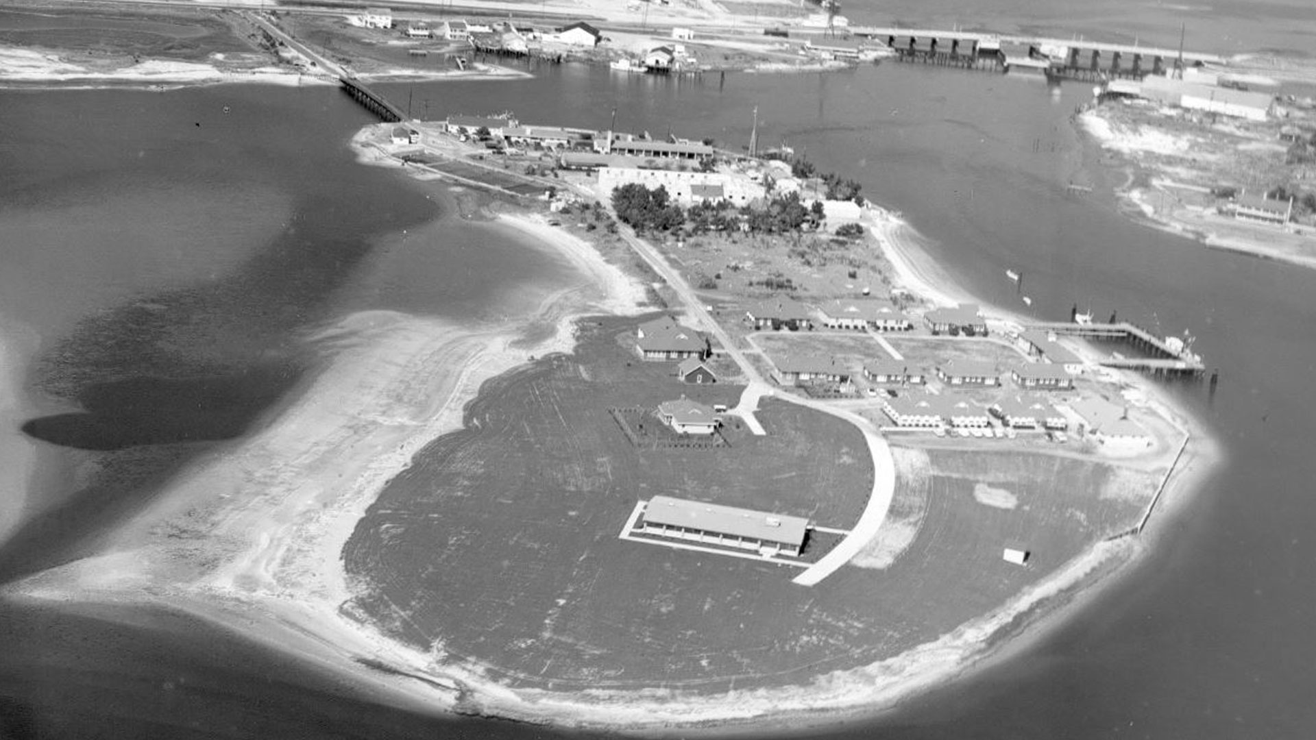 A black a white aerial view of the marine lab from 1965 with sandy beaches