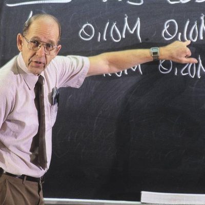 James Bonk pointing to a chalk board