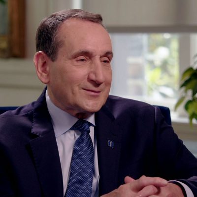 Coach K sitting for an interview with hands folded