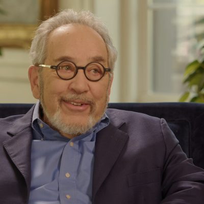 Peter Lange sitting in a chair between two plants